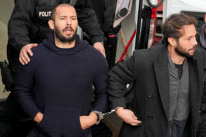 Police officers escort Andrew Tate, left, handcuffed to his brother Tristan Tate to the Court of Appeal in Bucharest, Romania, Wednesday, Feb. 1,