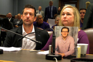 Stephen and Rae Ann Gruver sit at a table with a photo of their son.