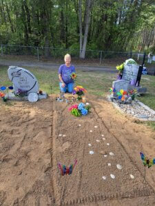 Sandy Smith sitting at fresh gravesite
