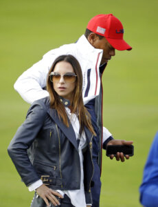Tiger Woods of the US stands with his partner Erica Herman