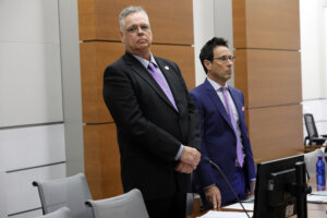 Scot Peterson stands with his attorney in court during jury selection.