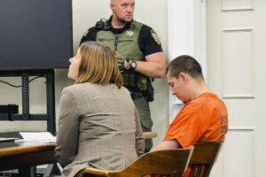 Majorjon Kaylor sits next to his attorney in court.