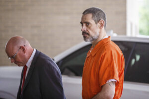 Casey White, wearing an orange jumpsuit, arrives at the courthouse.