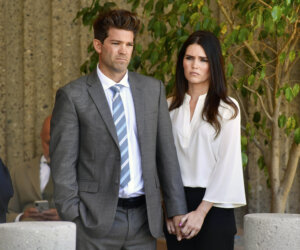 Dr. Grant Robicheaux and his girlfriend Cerissa Riley listen during a news conference