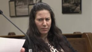 A woman sits in court