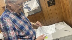 A man goes through papers in his hand