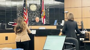 Attorneys and a judge talk in a courtroom.