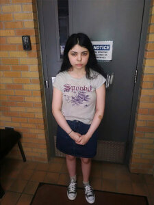 a girl stands in front of a door