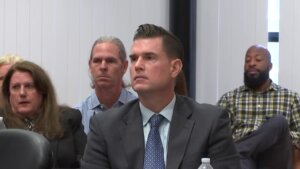 A man in a suit sits in court