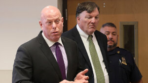 Rex Heuermann appears in court with his attorney. A deputy stands behind them.