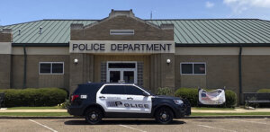 a police cruiser is parked outside of a building that says 'police department'