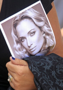 A mourner carries a program at the funeral for Reeva Steenkamp