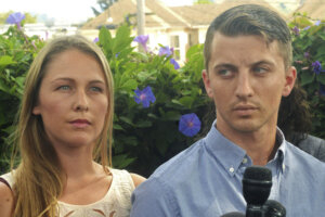 Denise Huskins, left, and her boyfriend, Aaron Quinn listen as their attorneys speak at a news conference