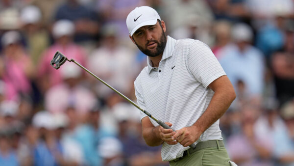 Scottie Scheffler holds a golf club at a tournament