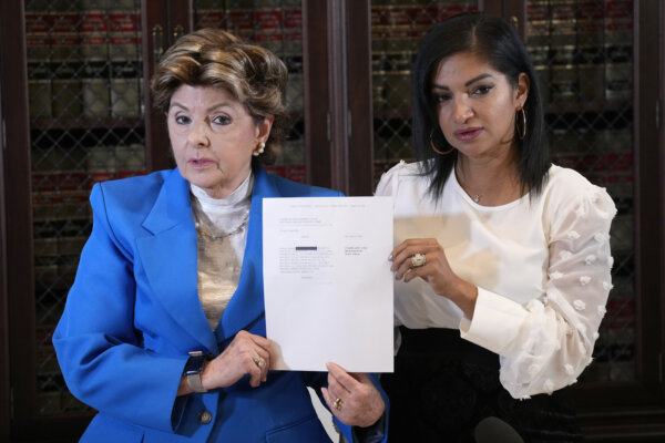 two women hold up paper