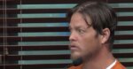 young man in orange prison jumper testifies