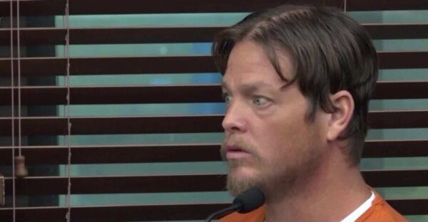 young man in orange prison jumper testifies