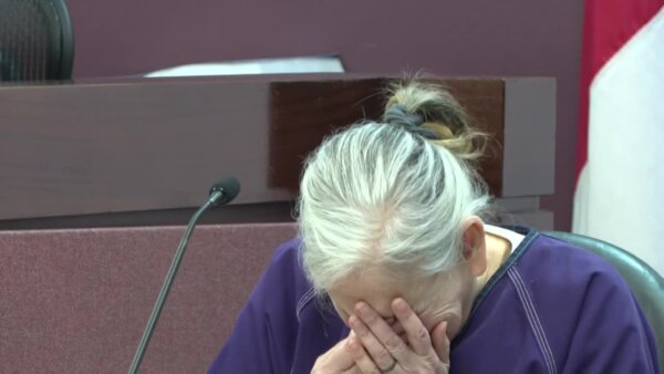 Donna Adelson has her head in her hands as she cries