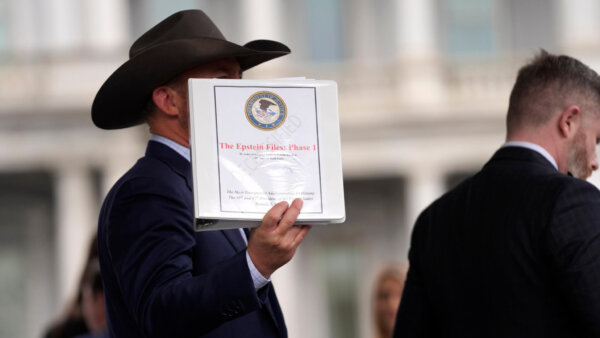 man holds up documents