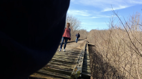 young girl being followed on a bridge in a rural area