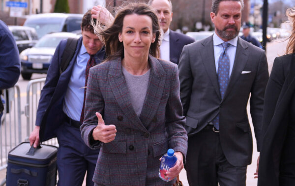 Karen Read gives a thumbs up while walking into court with her attorneys