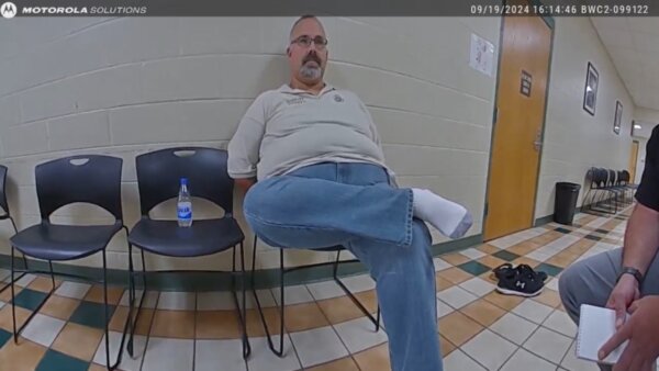 Sheriff Shawn 'Mickey' Stines sits on a chair in courthouse hallway