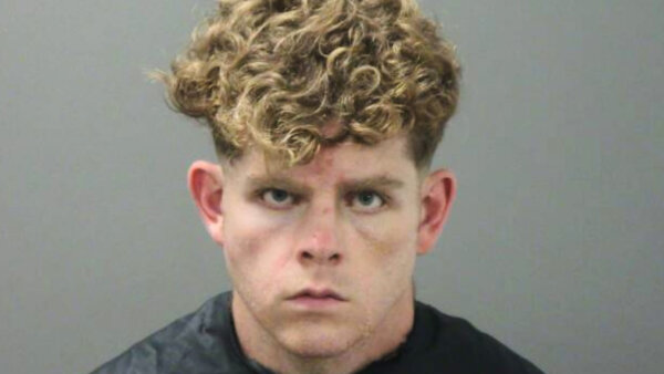 mugshot of a young, blonde, curly-haired man