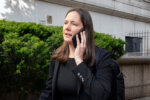 woman on a cell phone wears all black