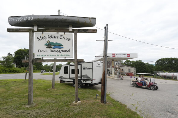 Campers ride a golf cart to the Mic Mac Cove Campground