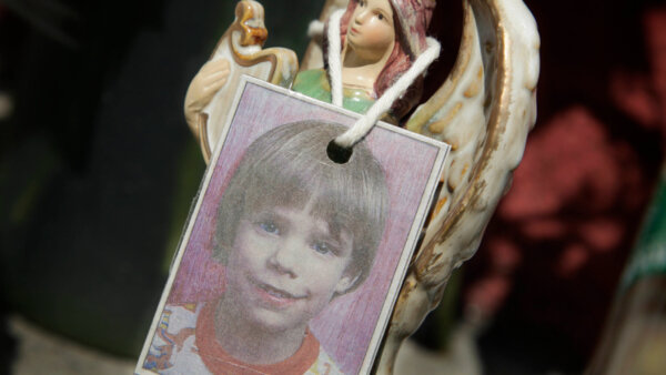 A photograph of Etan Patz hangs on an angel figurine
