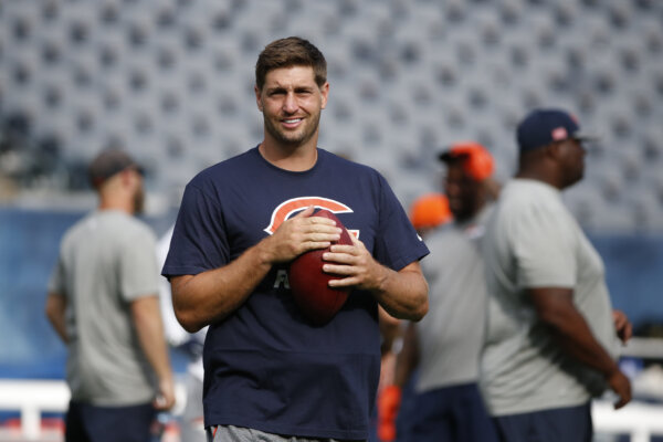 jay cutler holds a football