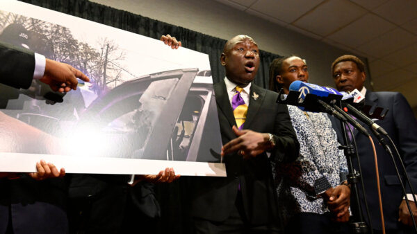 William McNeil Jr.'s attorney Ben Crump, center, speaks while showing a still from a police body cam video during a press conference