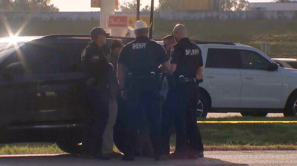aw enforcement officials investigate a vehicle near the scene of a deadly shooting