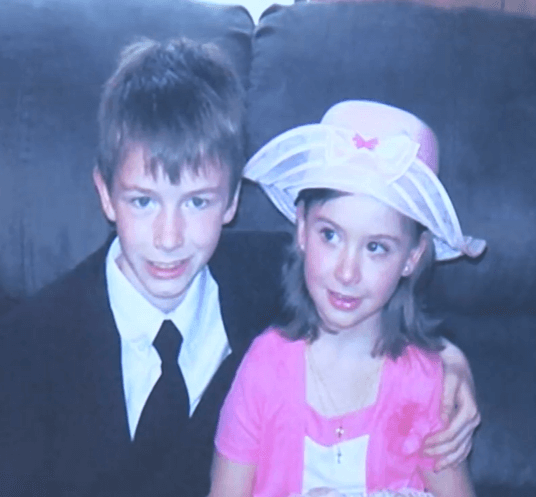 Photo of a young boy with his arm around a young girl in a pink hat