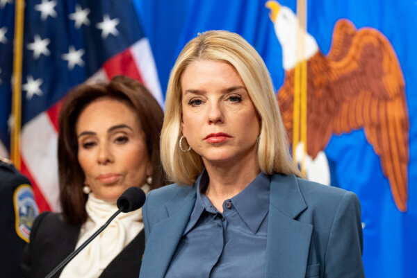 Attorney General Pam Bondi, with U.S. Attorney Jeanine Pirro behind, pauses while speaking