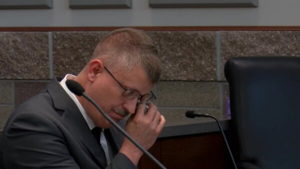 Joseph Schroer wipes away a tear in court