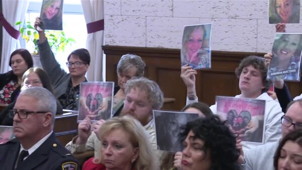 Photos of Amanda Dean are held up in court by people sitting in the gallery.