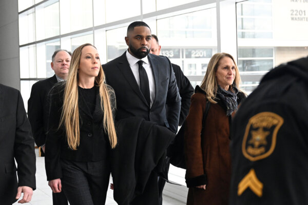 Sherrone Moore, second from right, walks with his wife