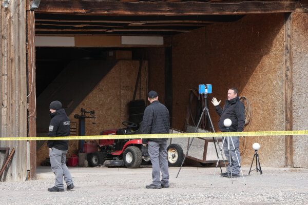 detectives investigate an open space blocked off by crime scene tape