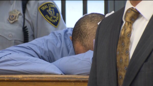 man has head on arms in court