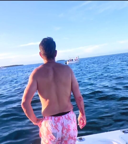 George Pino stands on a boat